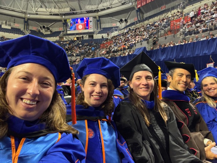 PhD students and professors seated at a graduation ceremony